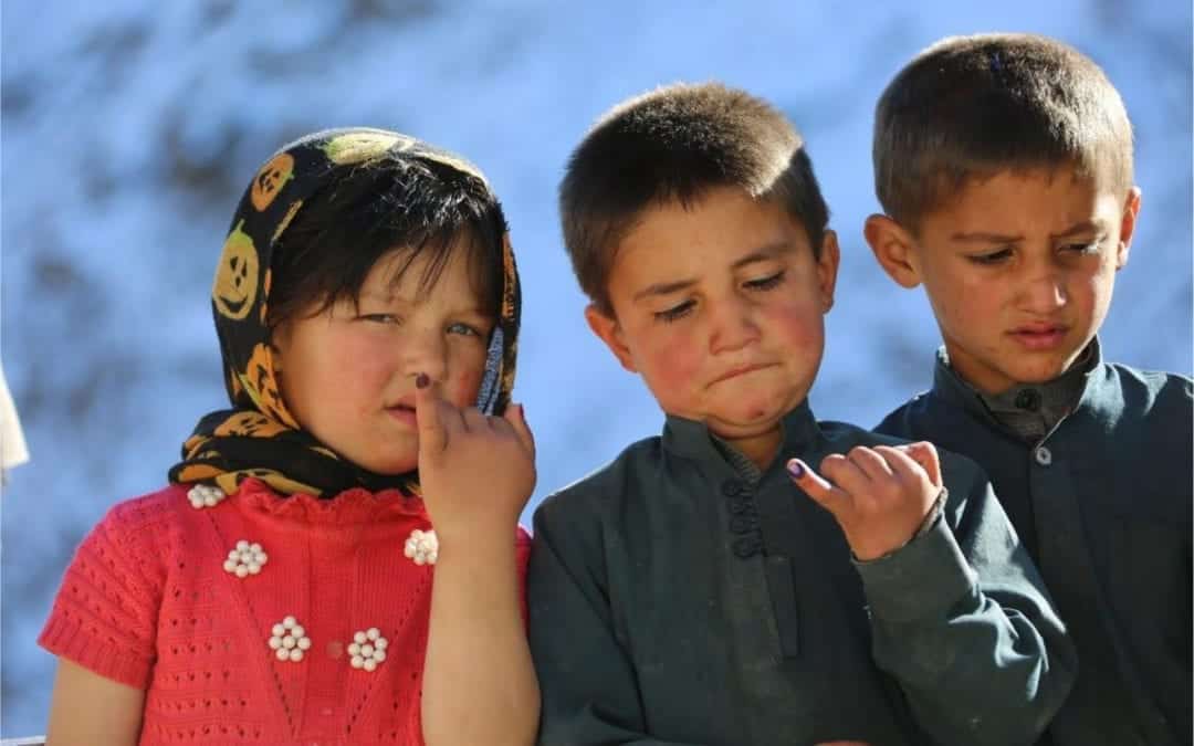 Children show their inked fingers after vaccination against polio