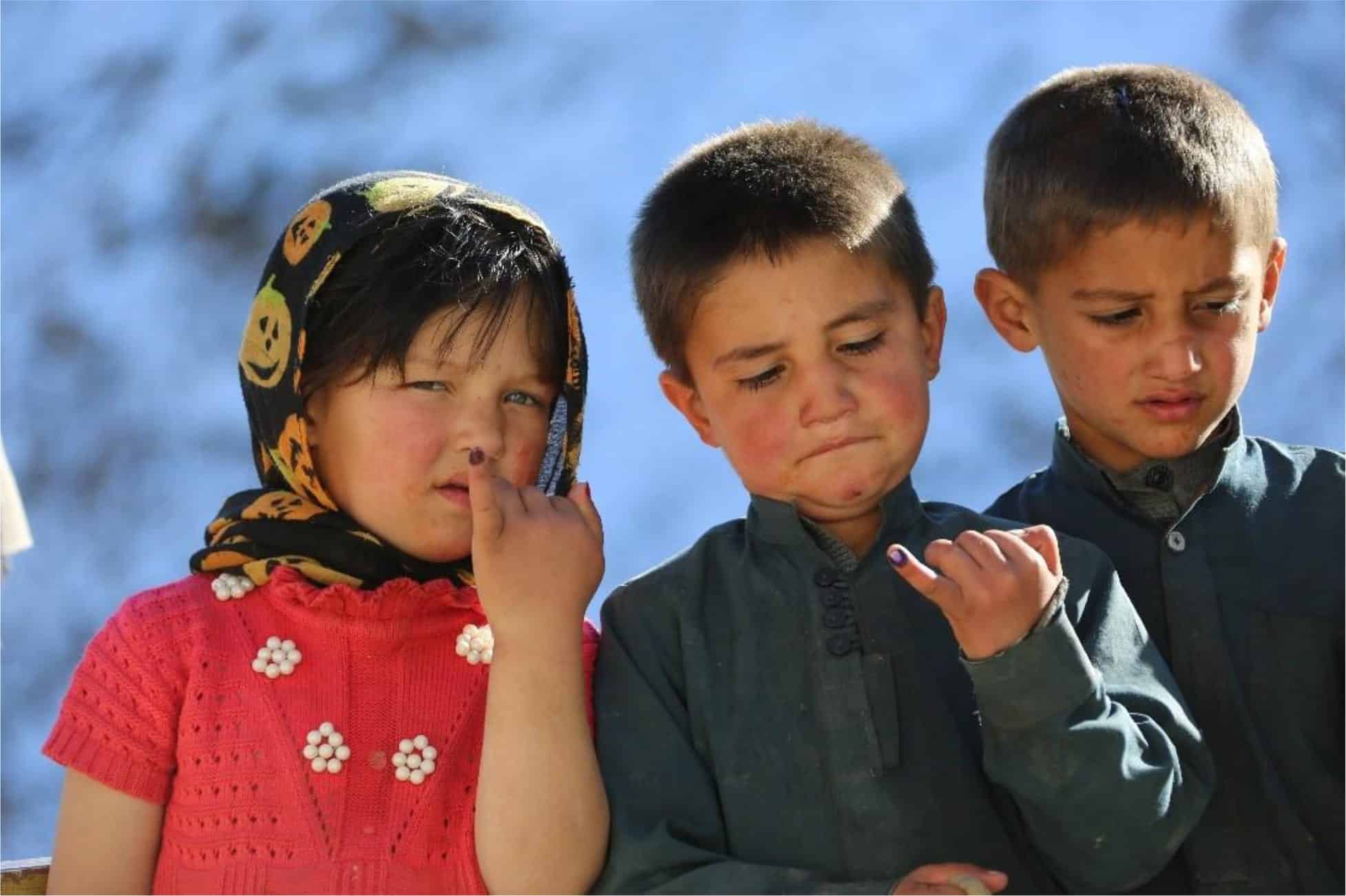 Children show their inked fingers after being vaccinated against polio in Afghanistan