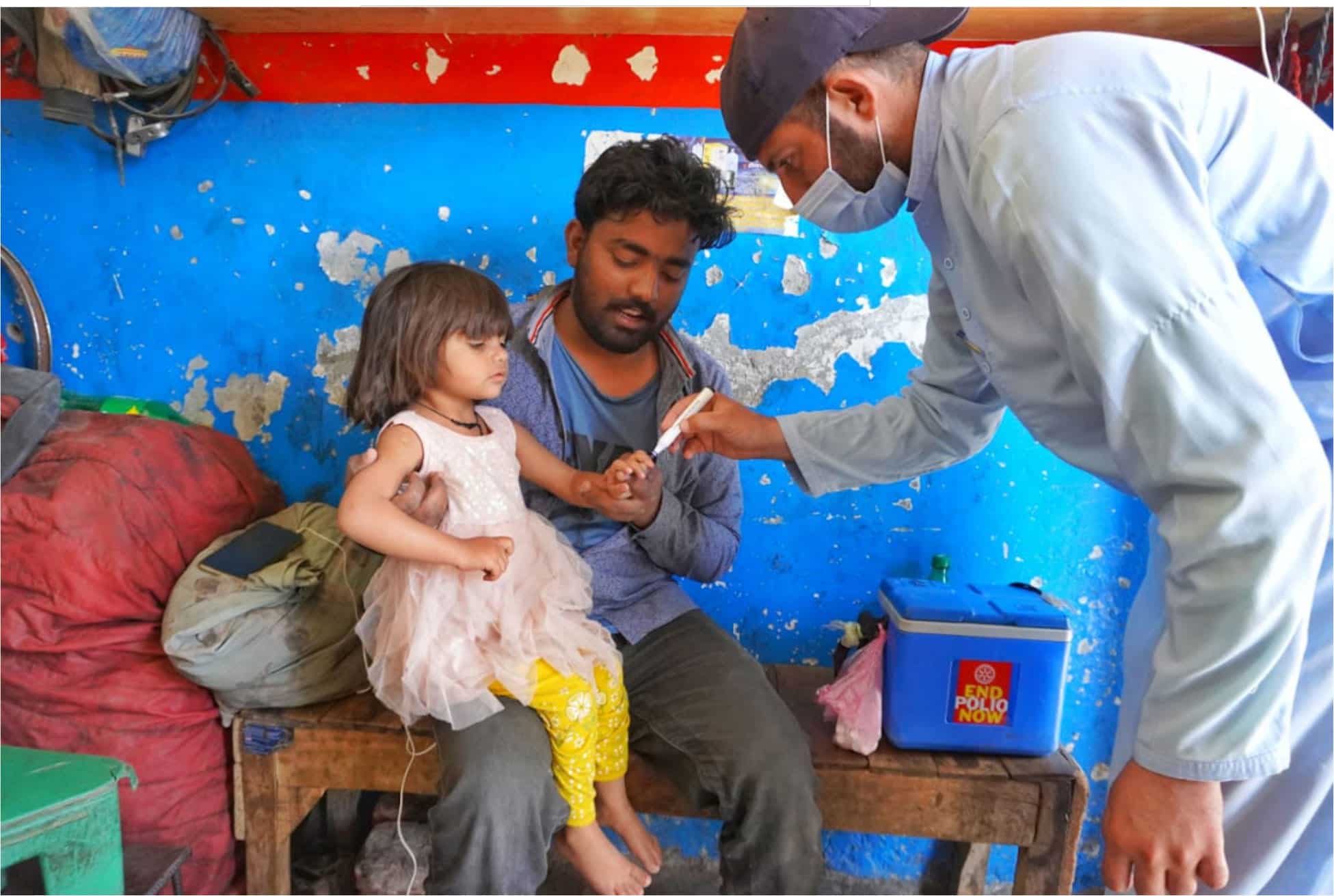 A vaccinator marking a vaccinated child