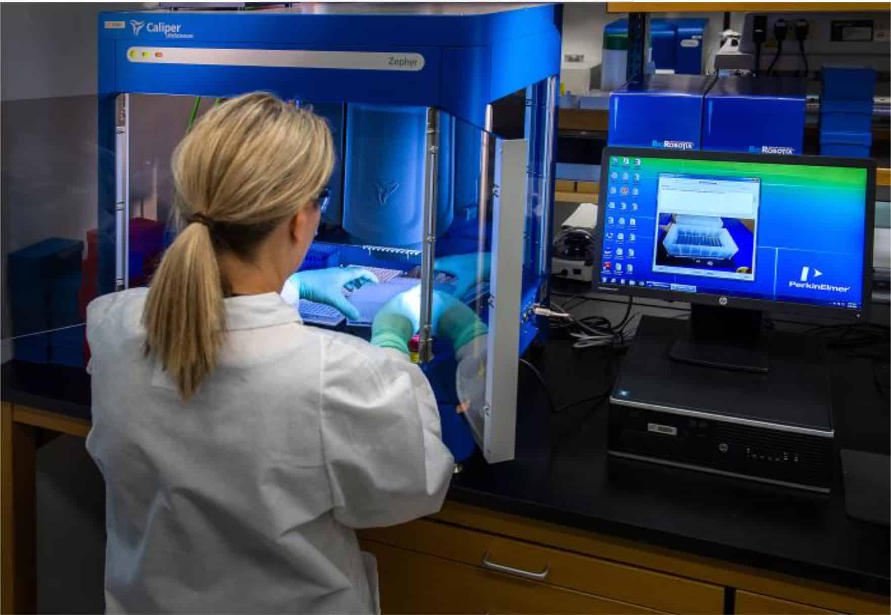 CDC scientist interacting with her Caliper LifeSciences’ Zephyr Molecular Biology Workstation